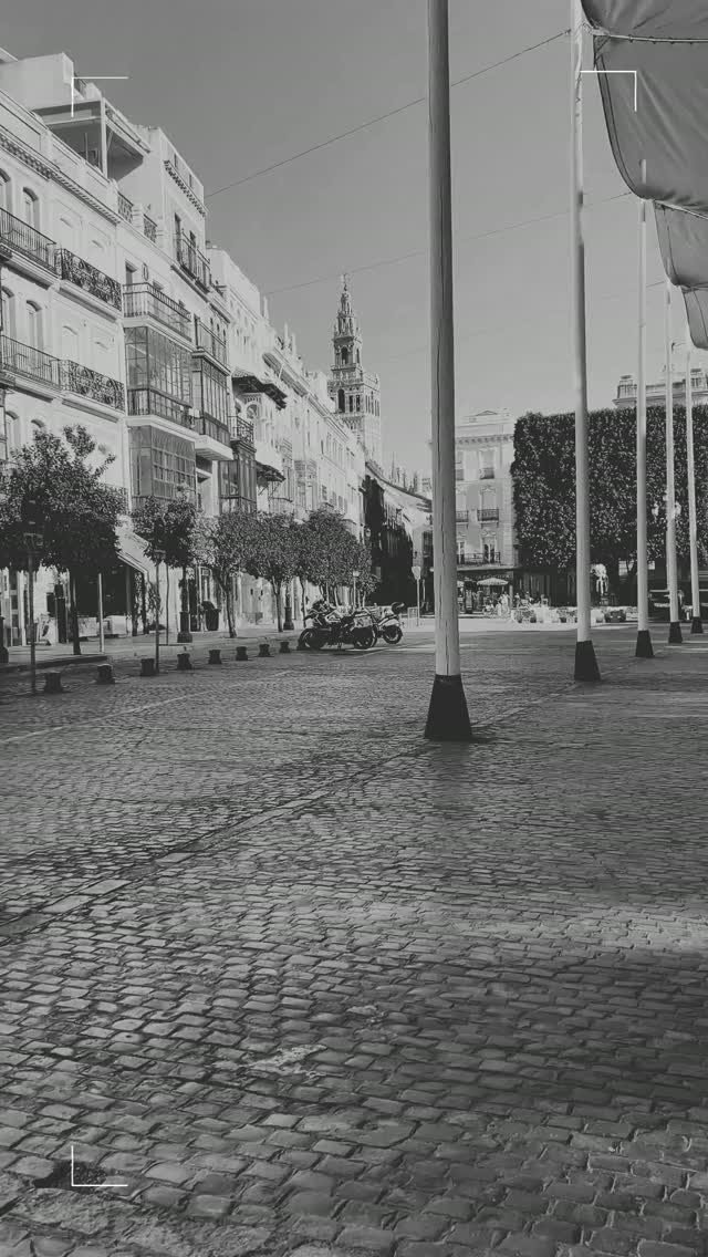 Calle del centro de Sevilla en blanco y negro, con la Giralda al fondo